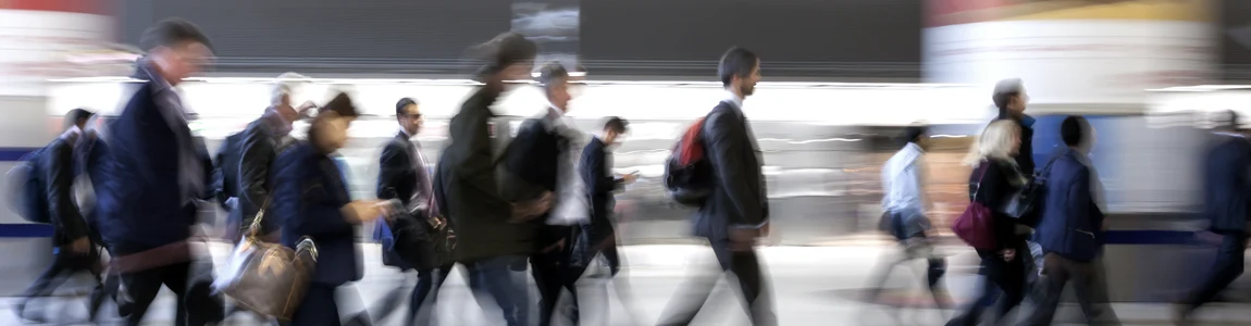 Blurred image of people moving through a modern transport facility space like a train station or airport