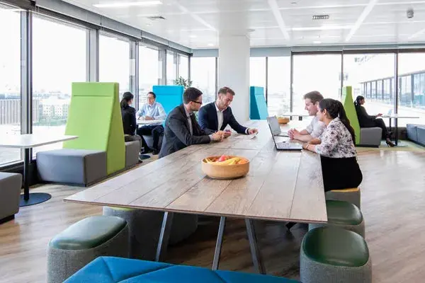Downing staff seated in open plan office environment overlooking the Thames River