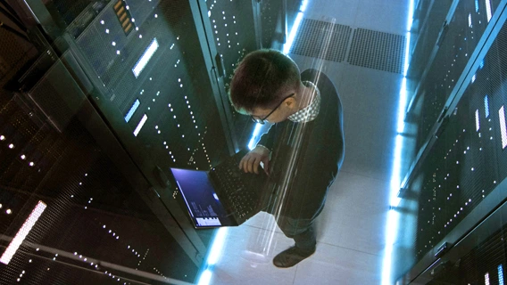 IT specialist inspecting a laptop in a managed hosting environment