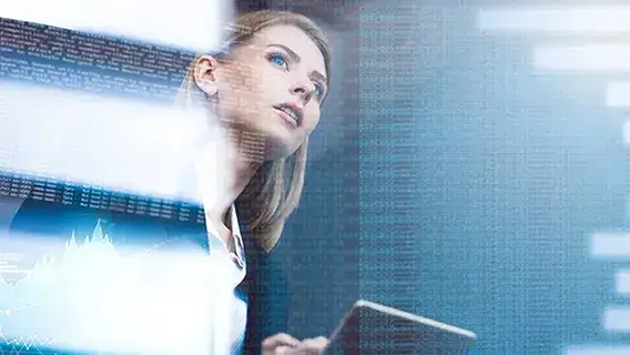 Female IT professional inspecting transparent digital display in dimly lit office environment
